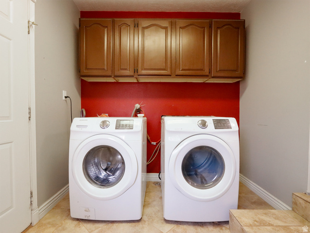 270 East 100 North Monroe, UT 84754 - Photo 21 of 65 Dedicated laundry area featuring overhead wood-finish cabinetry, a red accent wall, and ceramic tile flooring