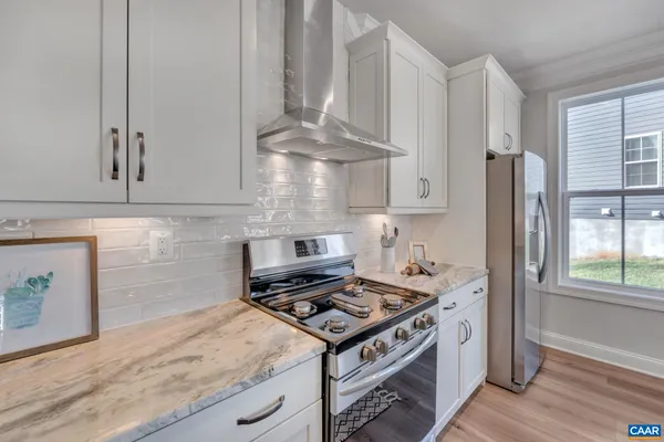 a kitchen with stainless steel appliances granite countertop a stove and a refrigerator