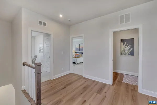 a view of a hallway with wooden floor and closet