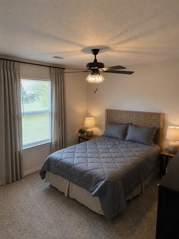 2998 Knob Road Springtown, TX 76082 - Photo 9 of 12 Carpeted bedroom featuring a window with blinds, ceiling fan with integrated lighting, and neutral wall tones