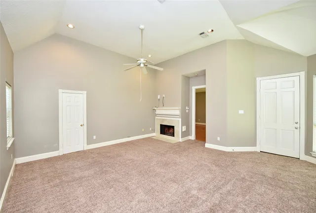 an empty room with fan and windows