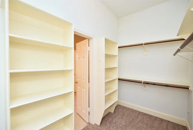 a view of walk in closet with empty racks