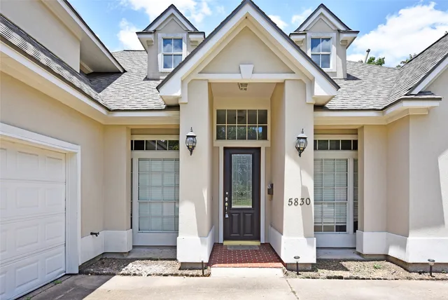a front view of a house with a tree