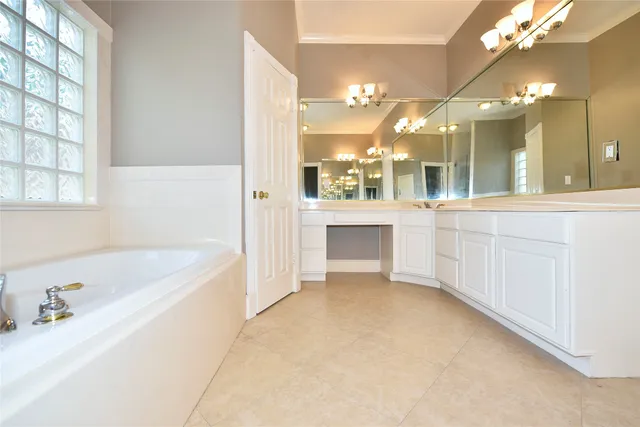 a bathroom with a tub a sink and a large mirror