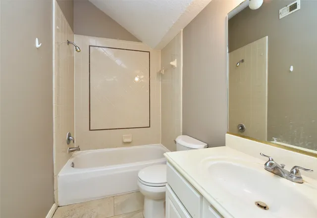 a bathroom with a bathtub shower sink vanity and toilet