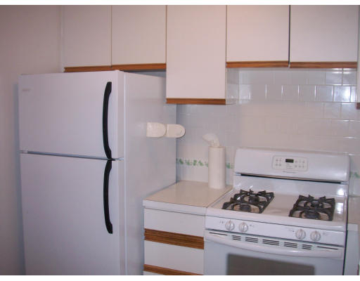 44 Washington Street, Unit 418 Brookline, MA 02445 - Photo 2 of 9 a kitchen with a refrigerator and white cabinets