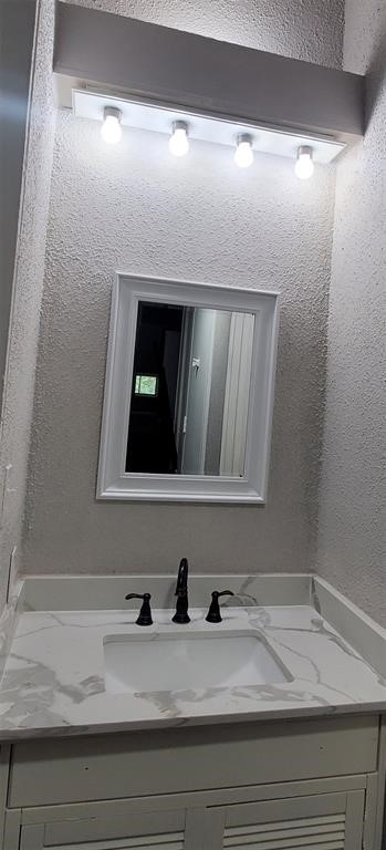 28 Lakeway Street Conroe, TX 77304 - Photo 7 of 10 a bathroom with a sink and a mirror