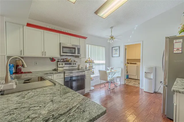 a kitchen with a refrigerator stove top oven and sink