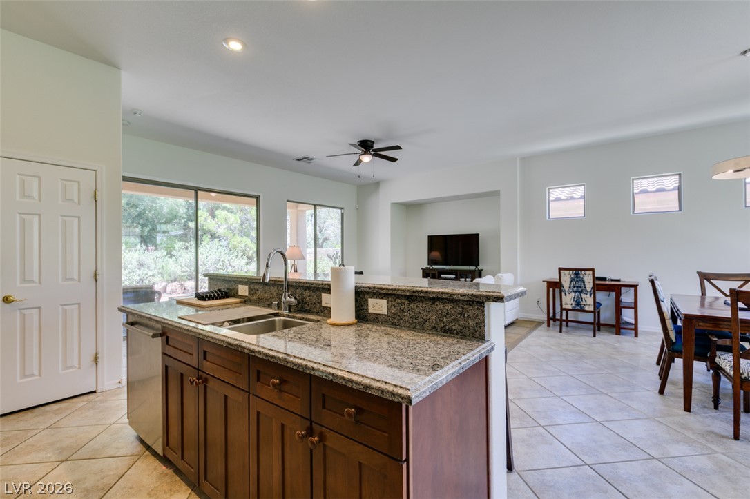 8 Kennesaw Road Henderson, NV 89052 - Photo 25 of 44 An open concept kitchen features granite counters and an inviting breakfast bar, flowing into the living and dining areas.