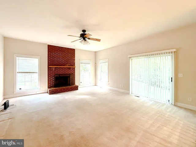 a view of empty room with a fireplace and fan