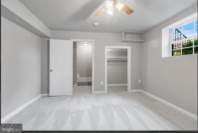 an empty room with closet and windows