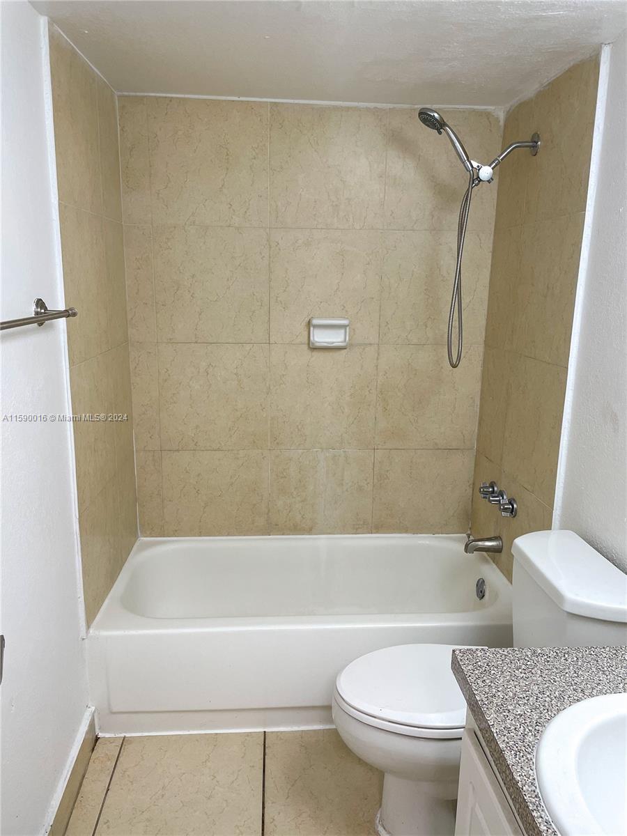 a bathroom with a granite countertop toilet sink and shower