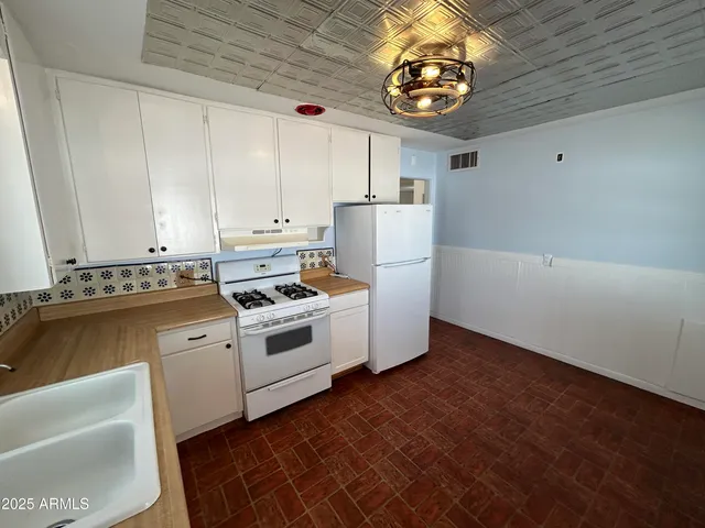 a kitchen with white cabinets and white appliances