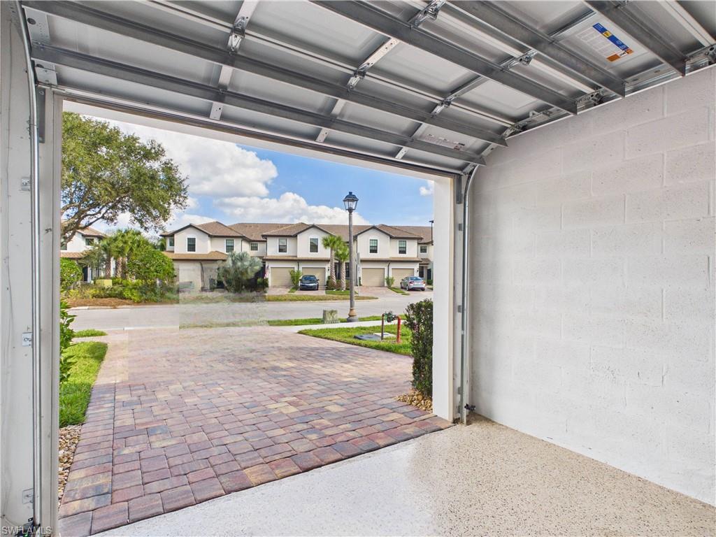 5683 Mayflower Way, Unit 908 Ave Maria, FL 34142 - Photo 35 of 37 Garage featuring concrete block wall and a residential view