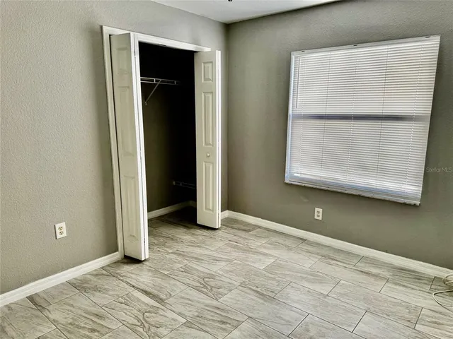 an empty room with a window and wooden floor