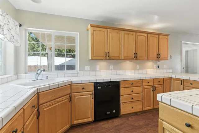 a kitchen with granite countertop cabinets sink and window