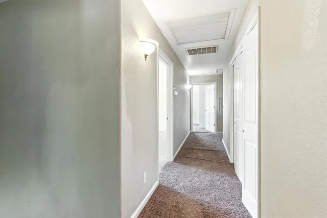 a view of a hallway with a white walls and stairs
