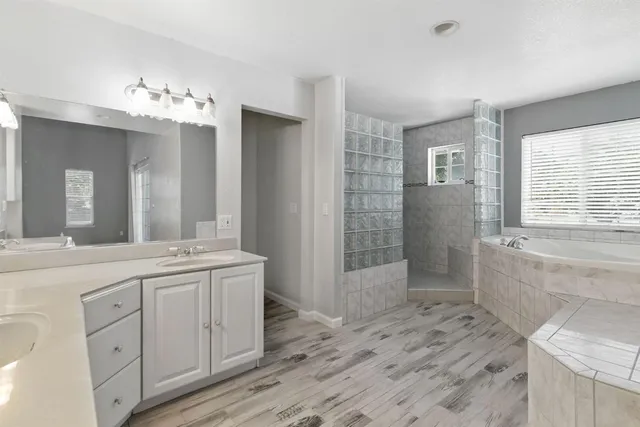 a bathroom with a granite countertop bathtub and shower