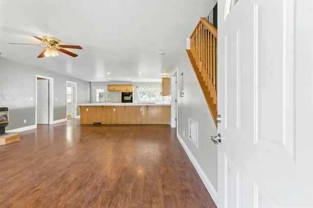 a view of a hallway with wooden floor and staircase