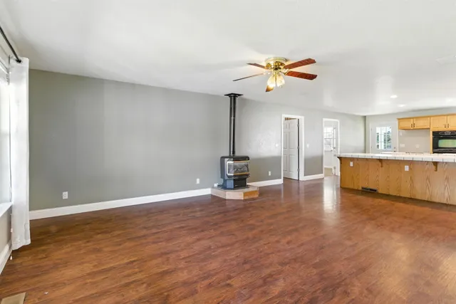 a view of a room with wooden floor and a ceiling fan