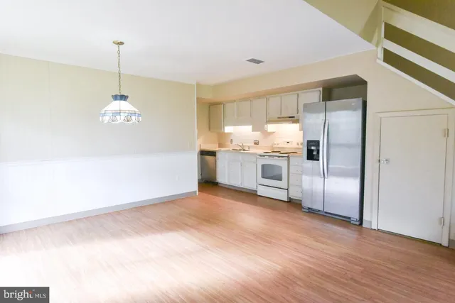 a kitchen with stainless steel appliances granite countertop a refrigerator a sink and a stove