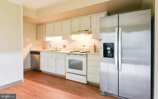 a kitchen with a refrigerator sink and cabinets