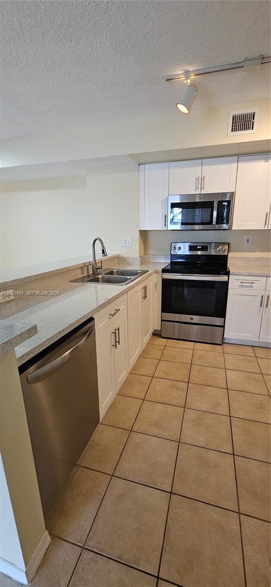 3870 Lyons Road, Unit 2098 Pompano Beach, FL 33073 - Photo 12 of 31 a kitchen with stainless steel appliances granite countertop a stove a sink and a microwave