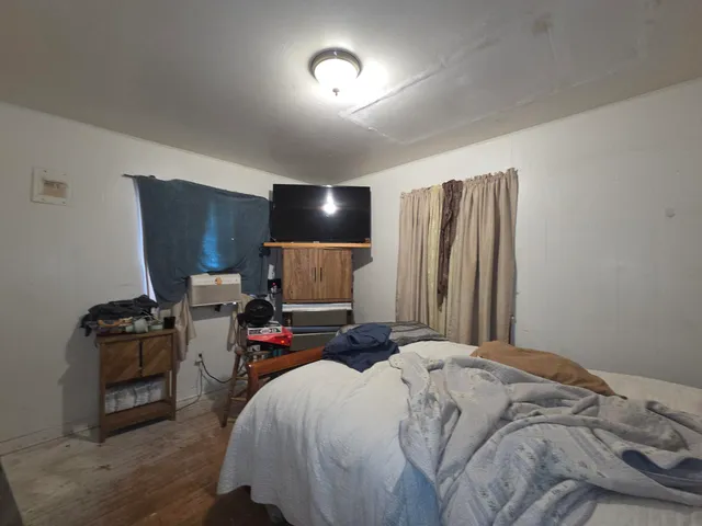 a bed sitting in a bedroom next to a tv
