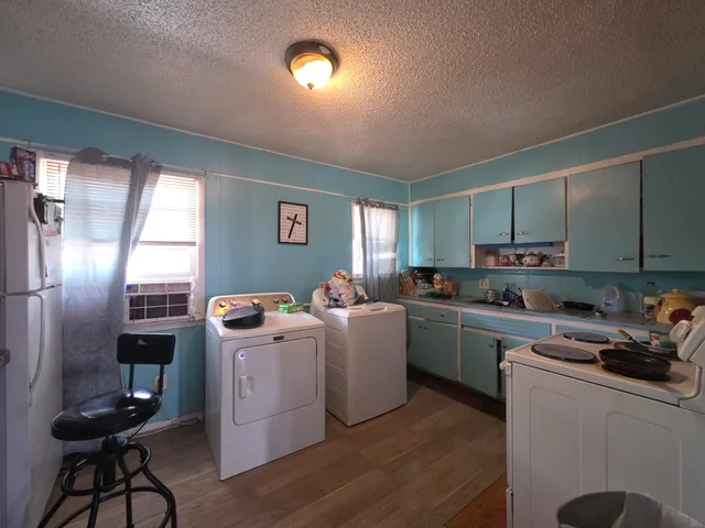 a open kitchen with cabinets a sink dishwasher a stove and a refrigerator with wooden floor