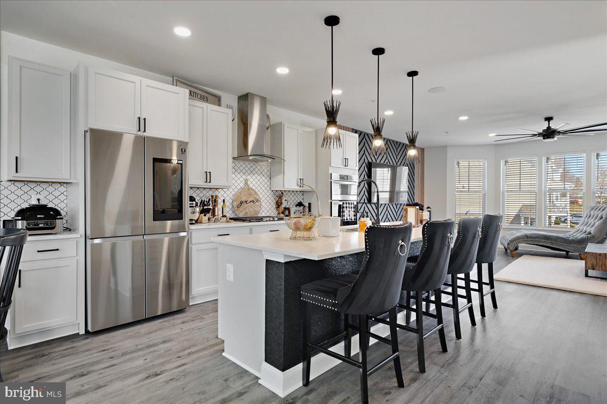 21 Greensborough Road Reisterstown, MD 21136 - Photo 11 of 54 a kitchen with stainless steel appliances a dining table chairs stove and refrigerator