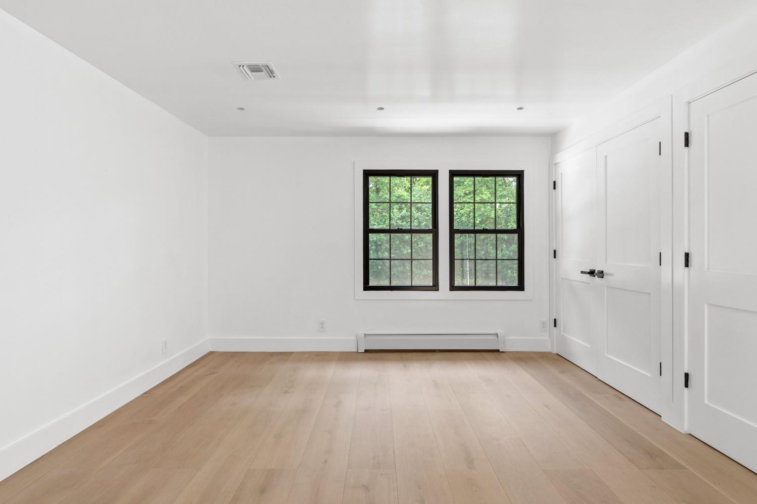 33 High Farms Road Glen Head, NY 11545 - Photo 17 of 35 1st Floor bedroom with light wood finished floors and a baseboard radiator