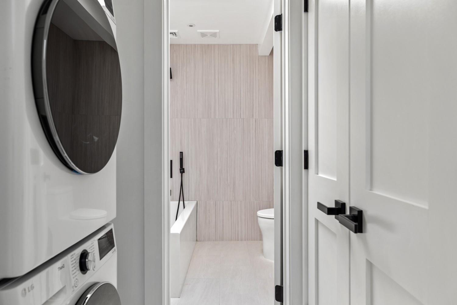 33 High Farms Road Glen Head, NY 11545 - Photo 25 of 35 Full bathroom featuring stacked washing machine and dryer, vanity, tile patterned flooring, and tile walls