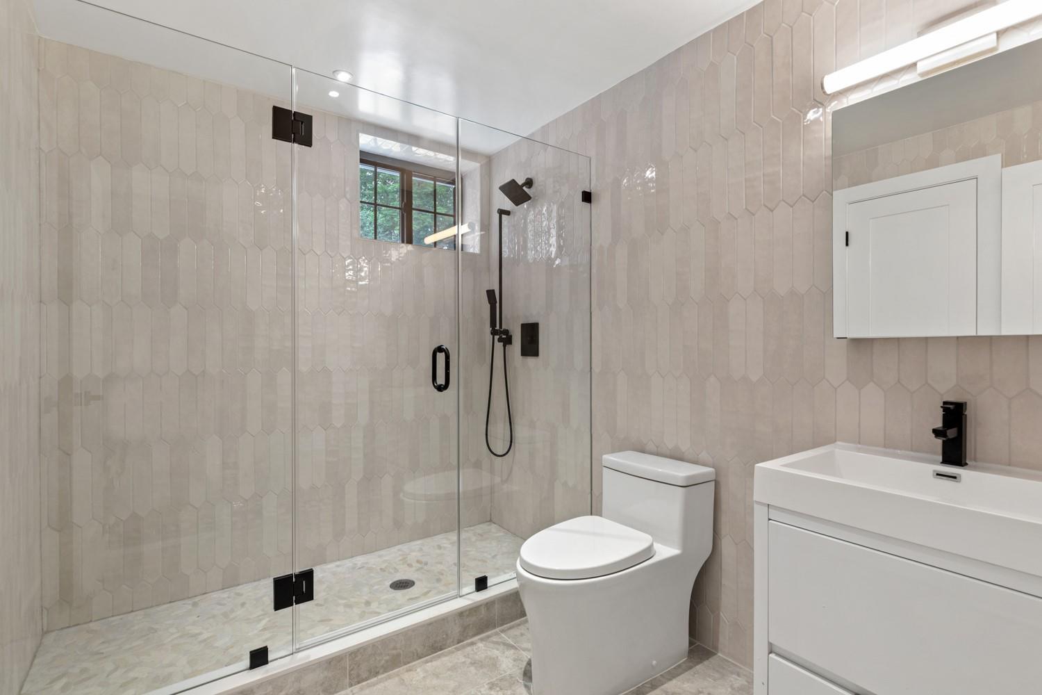33 High Farms Road Glen Head, NY 11545 - Photo 33 of 35 Lower Level Bathroom featuring vanity, a shower stall, and tile walls