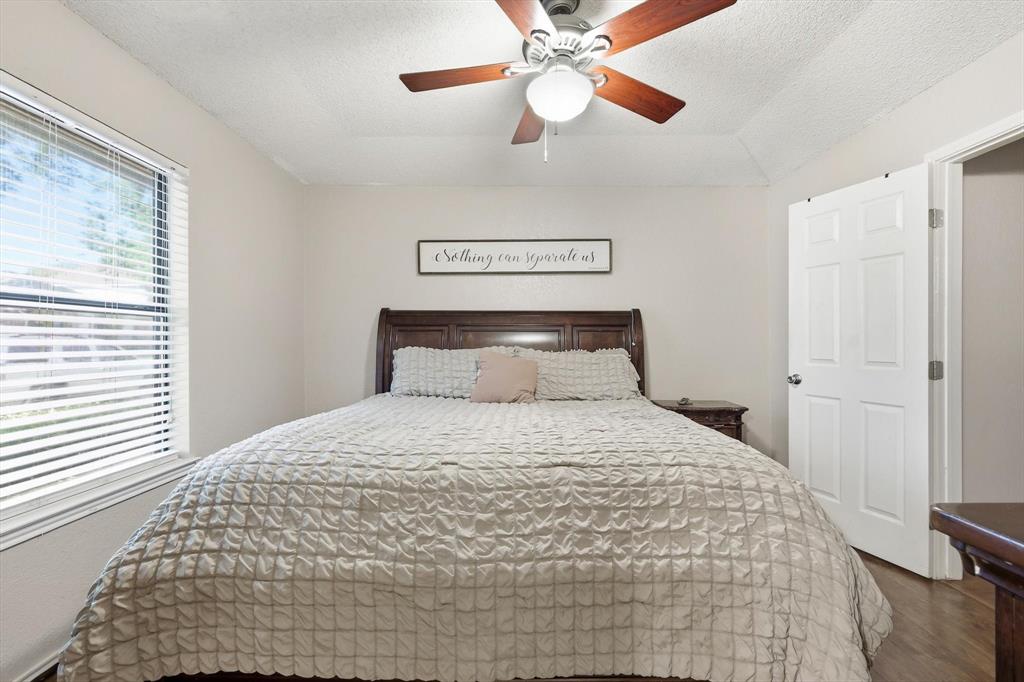 1312 Hackamore Street Mesquite, TX 75149 - Photo 13 of 23 Bedroom featuring a textured ceiling, ceiling fan, and dark wood finished floors