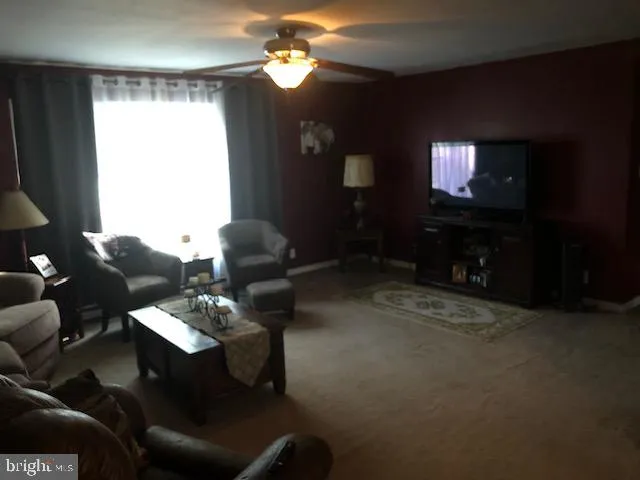 a living room with furniture a flat screen tv and a chandelier