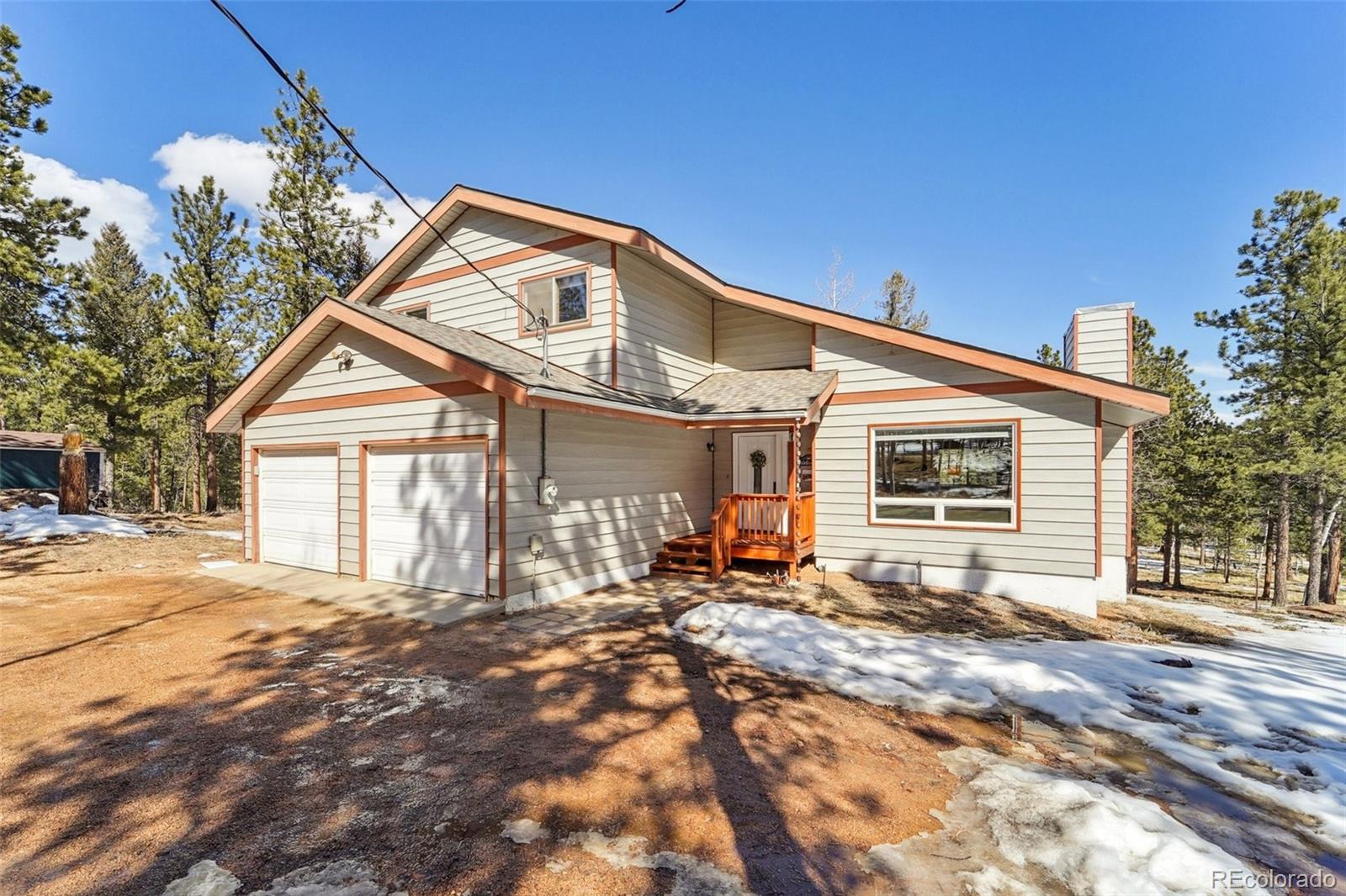 246 Tapadero Road Bailey, CO 80421 - Photo 1 of 50 a backyard of a house with large trees and outdoor seating