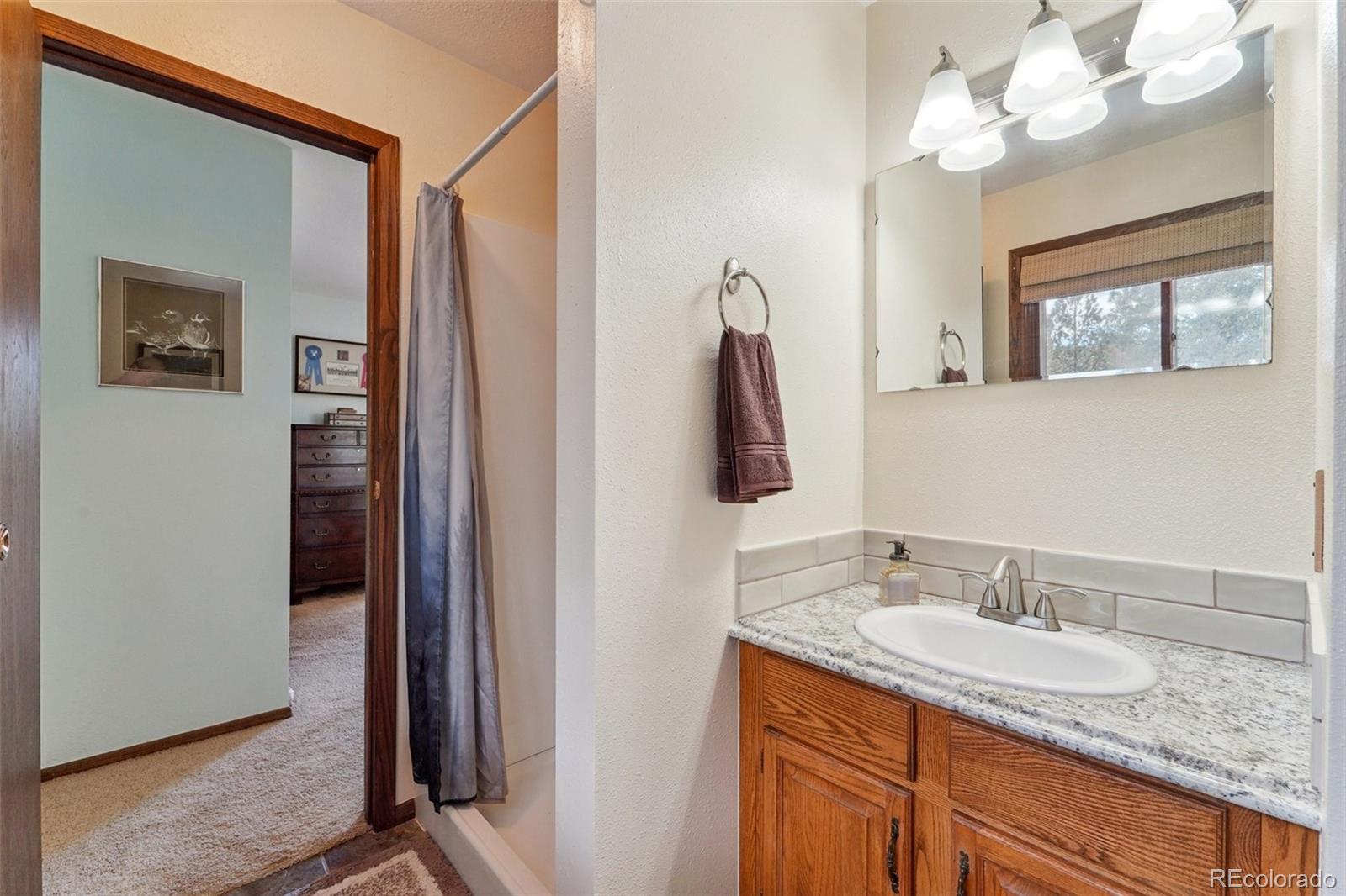 246 Tapadero Road Bailey, CO 80421 - Photo 24 of 50 a bathroom with a granite countertop double vanity sink and a mirror