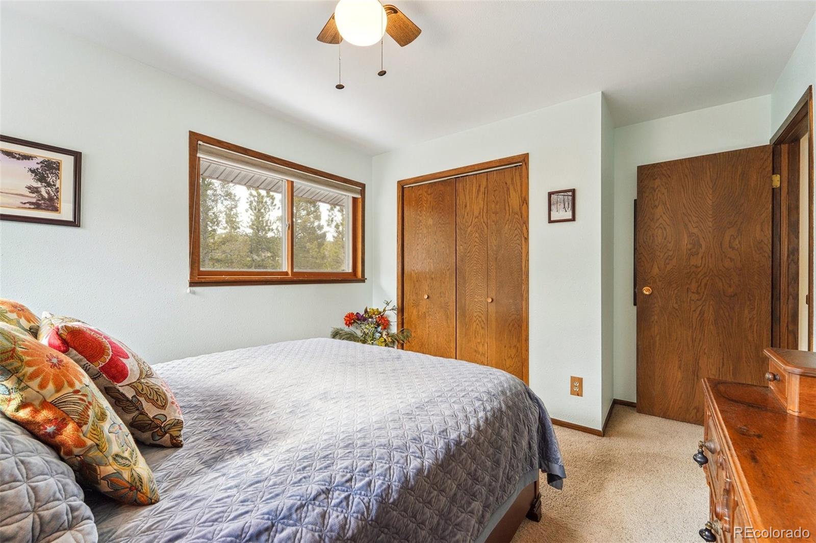246 Tapadero Road Bailey, CO 80421 - Photo 29 of 50 a bedroom with a bed and a chandelier