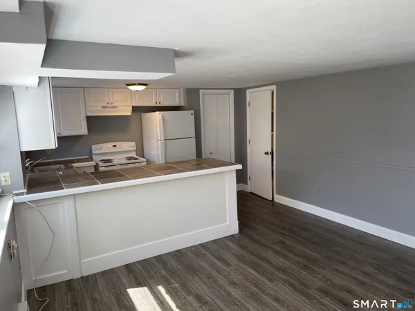a kitchen with a refrigerator and a stove top oven