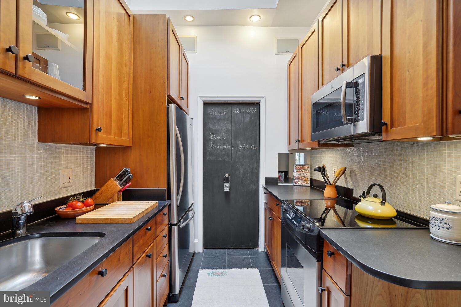2001 19th Street Northwest, Unit 10 Washington, DC 20009 - Photo 19 of 38 a kitchen with stainless steel appliances granite countertop a sink a stove and a refrigerator