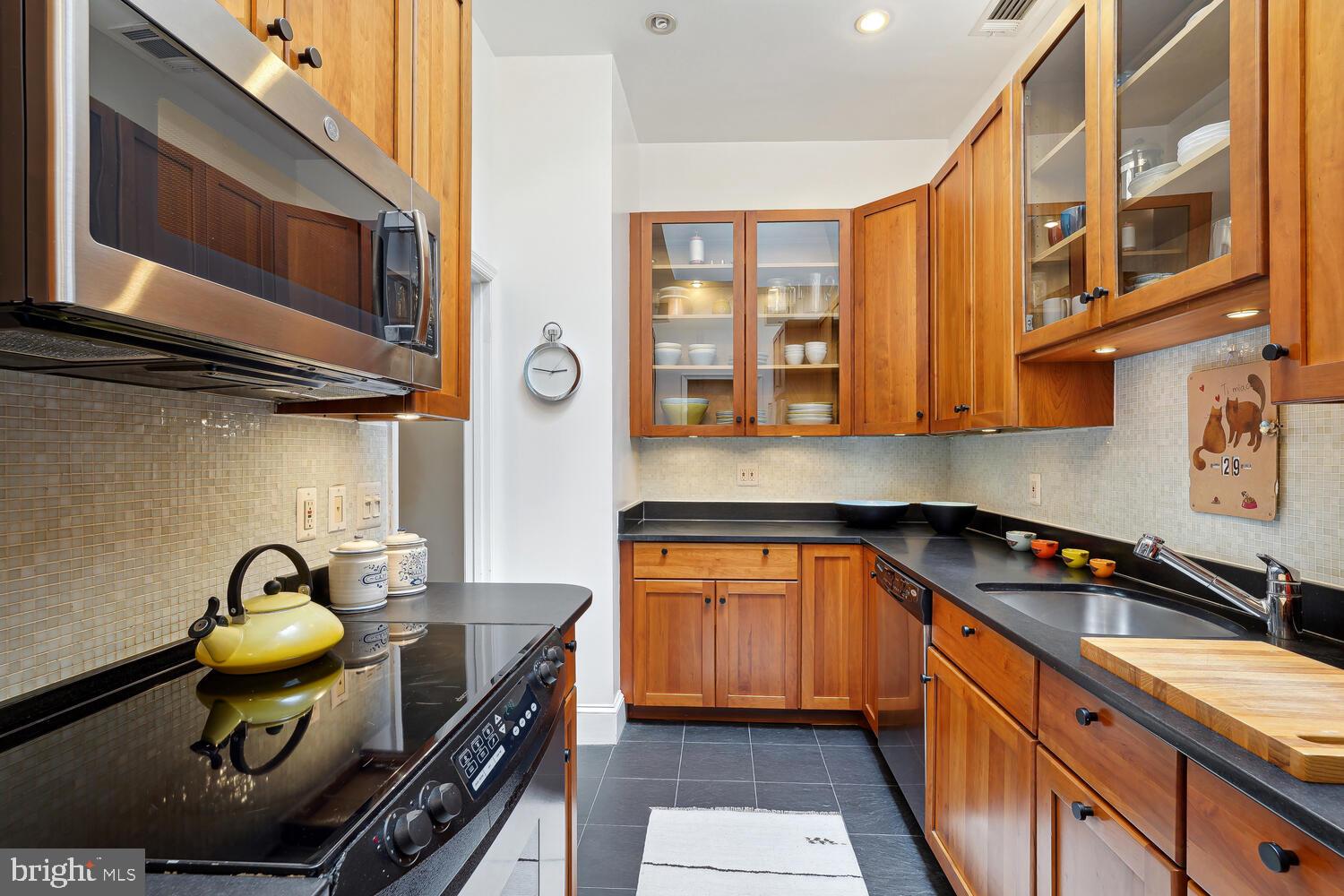 2001 19th Street Northwest, Unit 10 Washington, DC 20009 - Photo 20 of 38 a kitchen with stainless steel appliances granite countertop a stove a sink and a microwave