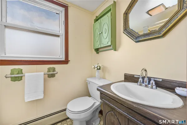 a bathroom with a toilet a sink and a mirror