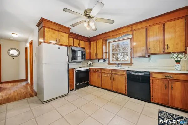 a kitchen with a refrigerator a stove a sink cabinets and a dining table