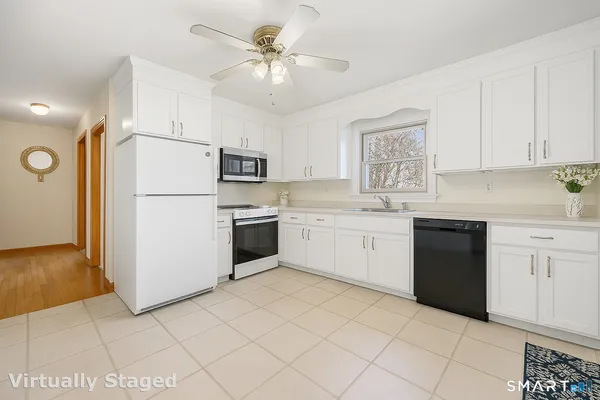 a kitchen with white cabinets sink and white appliances