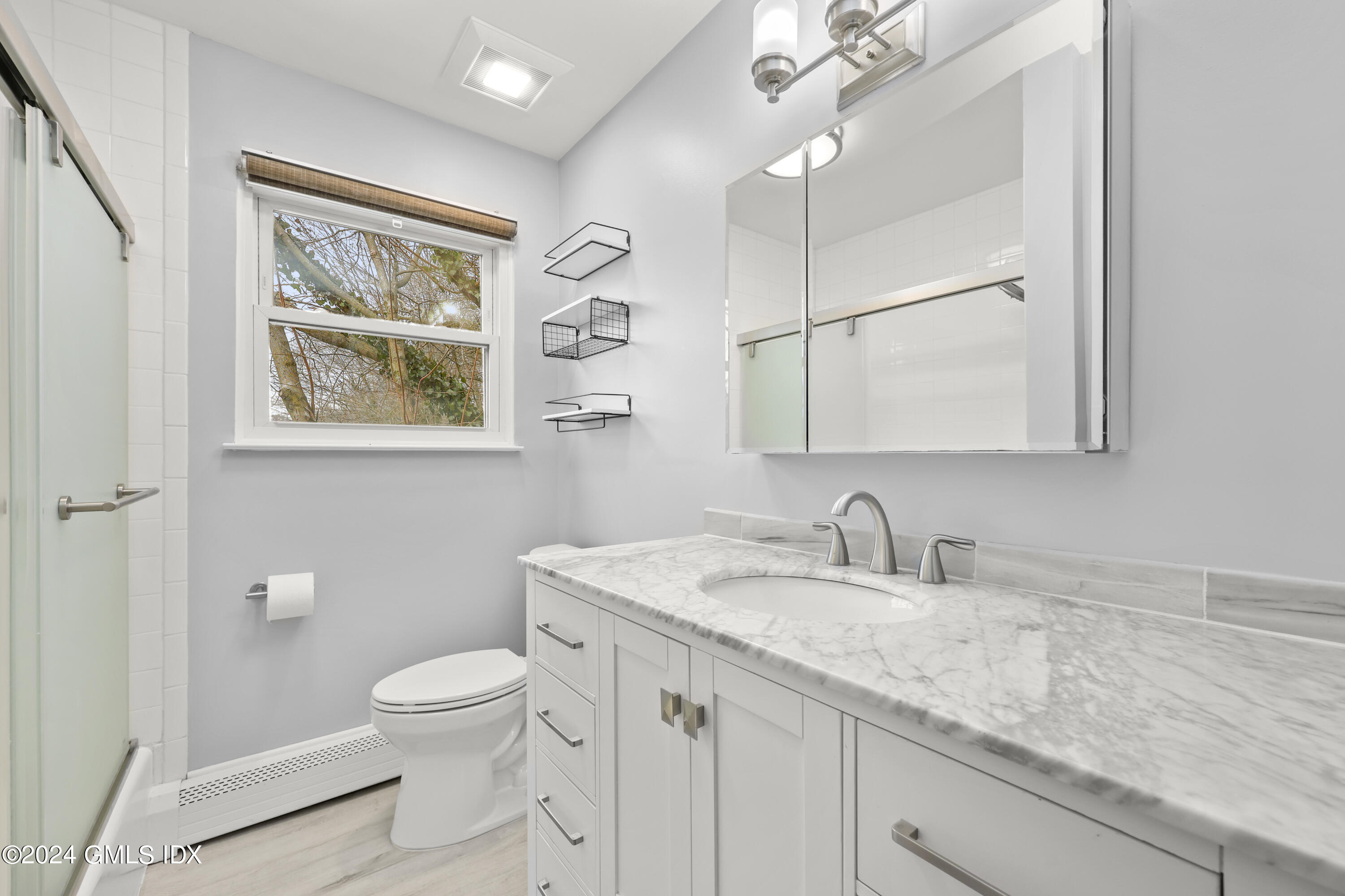 5 Green Lane, Unit A Greenwich, CT 06831 - Photo 15 of 24 a bathroom with a granite countertop sink mirror vanity and toilet