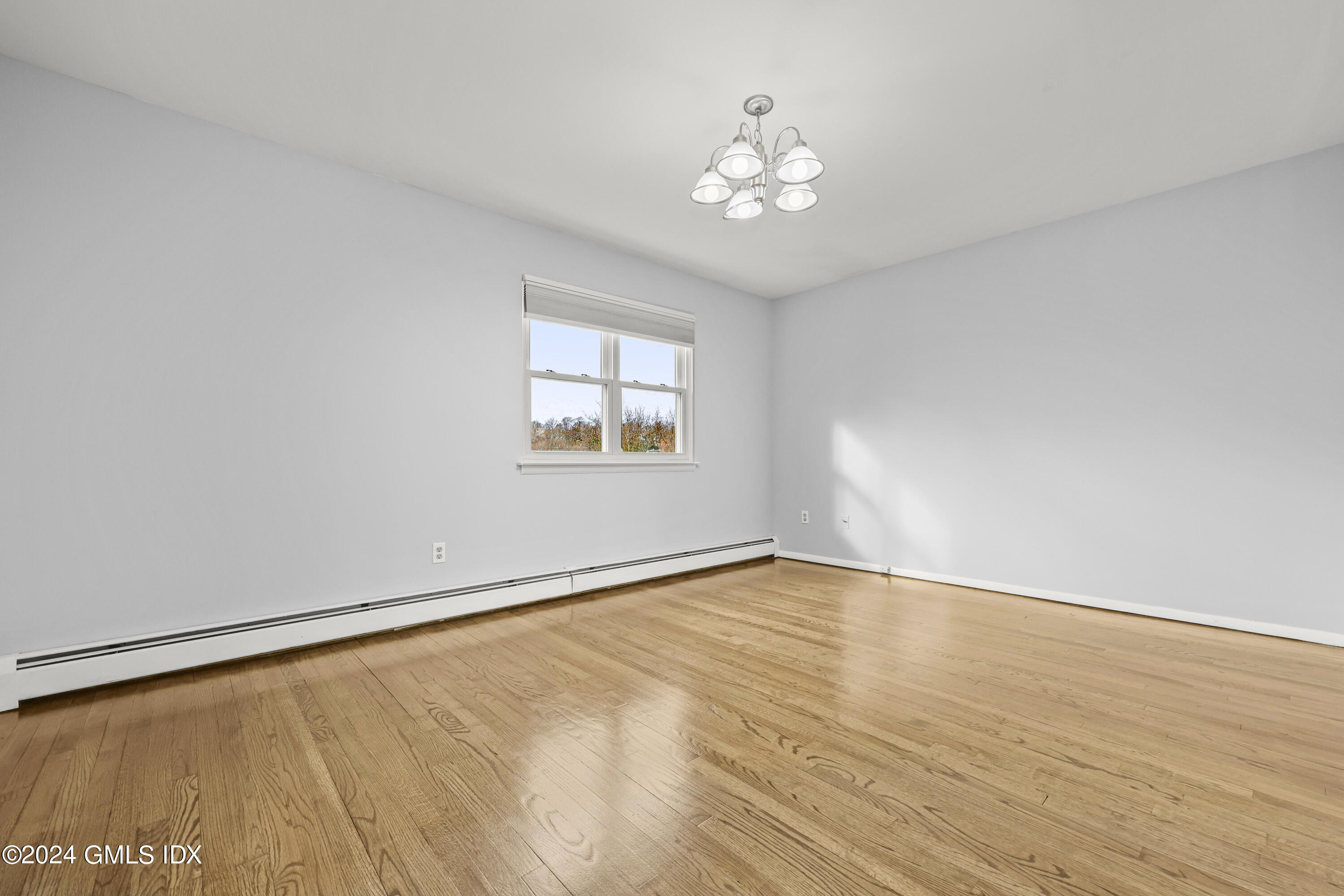 5 Green Lane, Unit A Greenwich, CT 06831 - Photo 17 of 24 a view of an empty room with wooden floor and a window