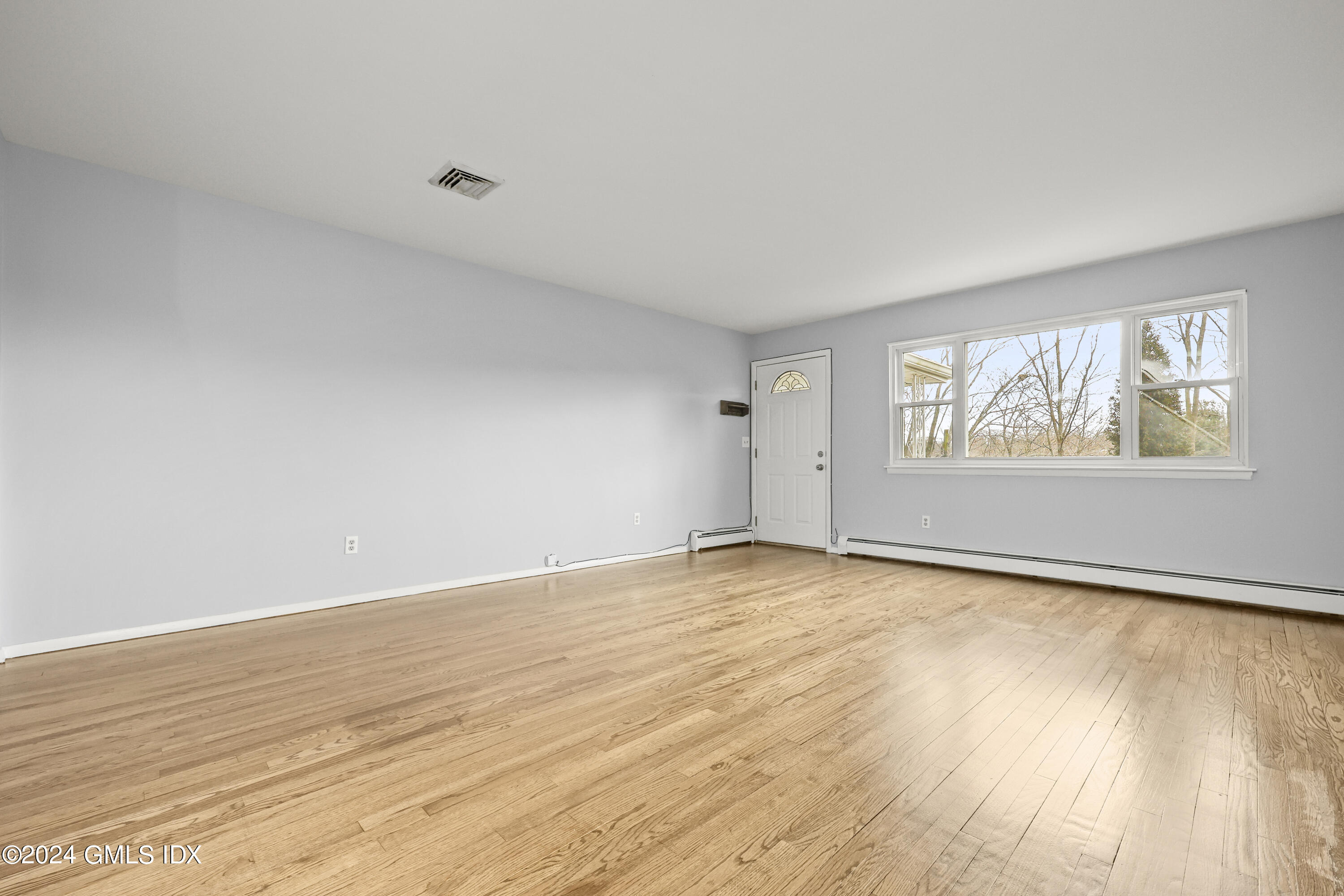 5 Green Lane, Unit A Greenwich, CT 06831 - Photo 7 of 24 a view of an empty room with wooden floor and a window