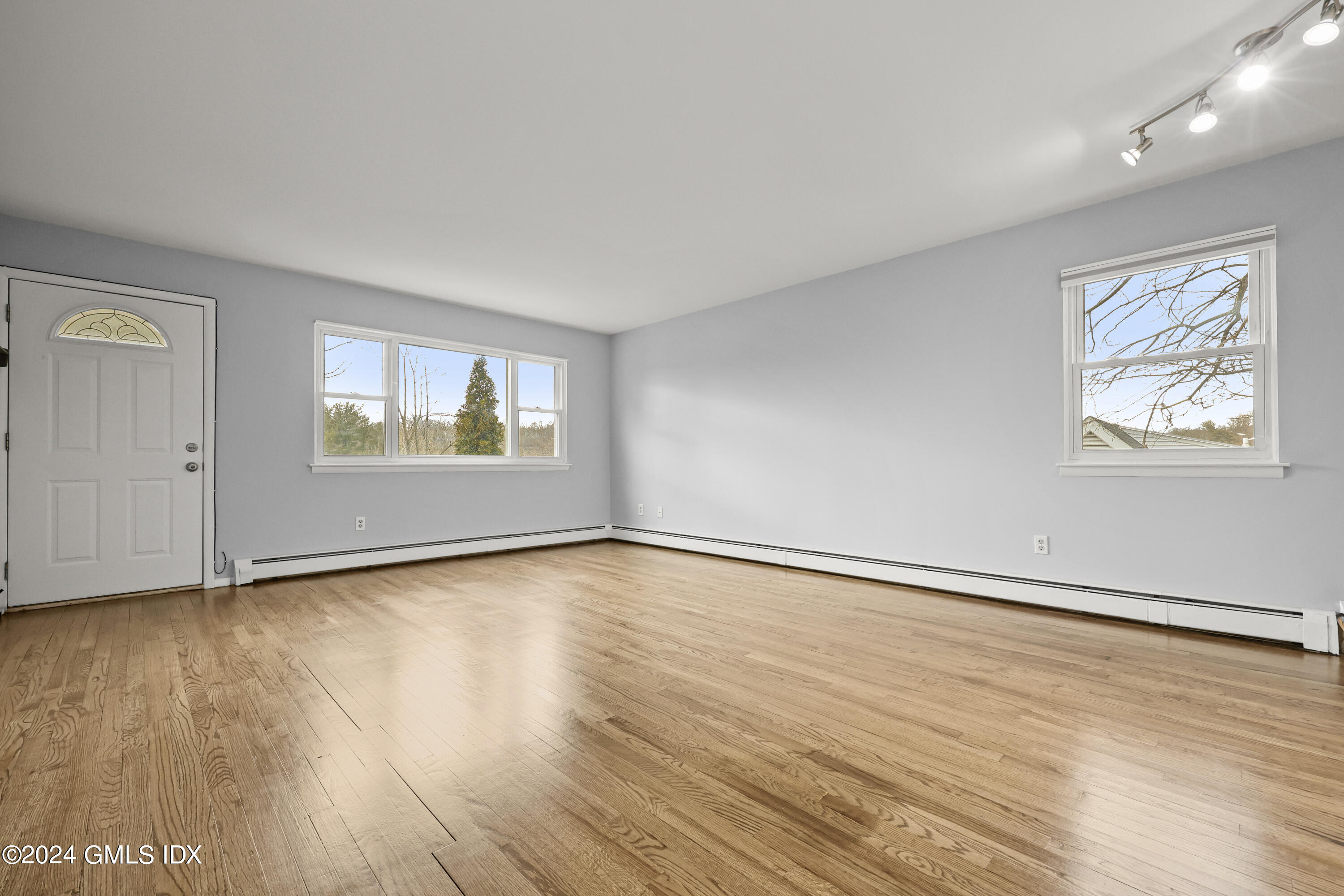 5 Green Lane, Unit A Greenwich, CT 06831 - Photo 8 of 24 an empty room with wooden floor and windows