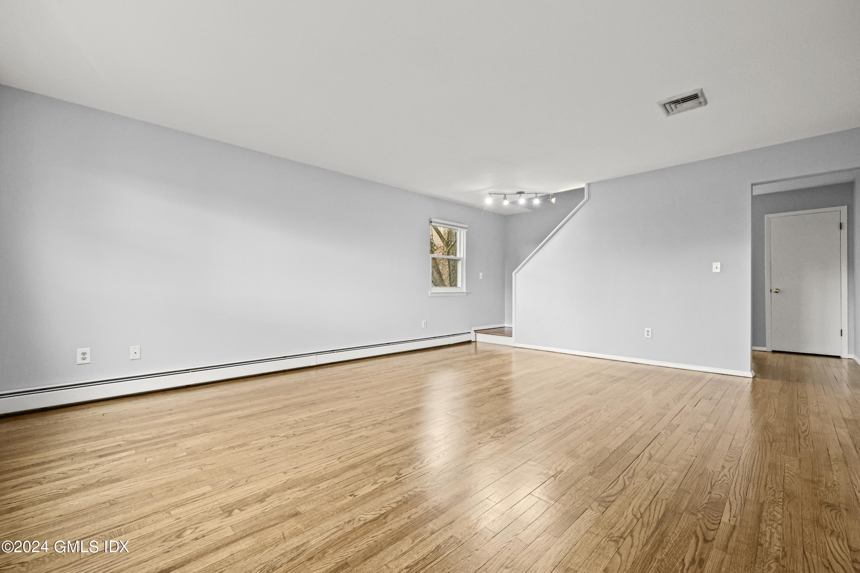 5 Green Lane, Unit A Greenwich, CT 06831 - Photo 9 of 24 a view of an empty room with wooden floor and a window