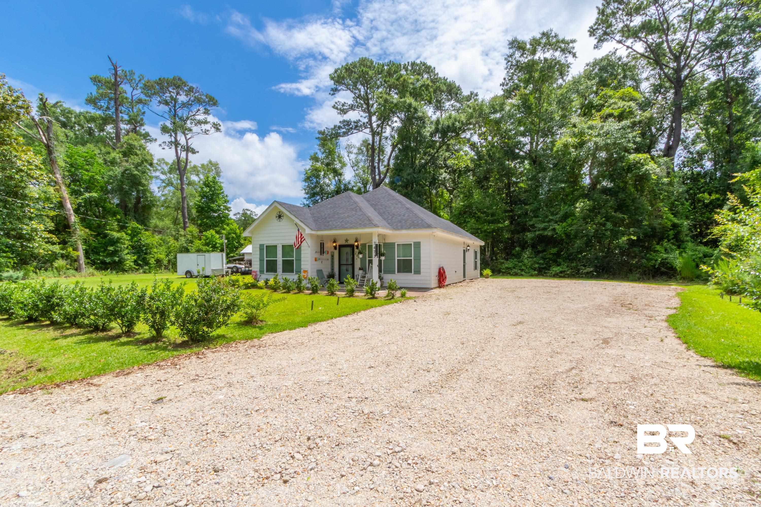 7472 Coopers Landing Road Foley, AL 36535 - Photo 26 of 40 White-sided home featuring a dark shingle roof, green window shutters, and a covered front porch